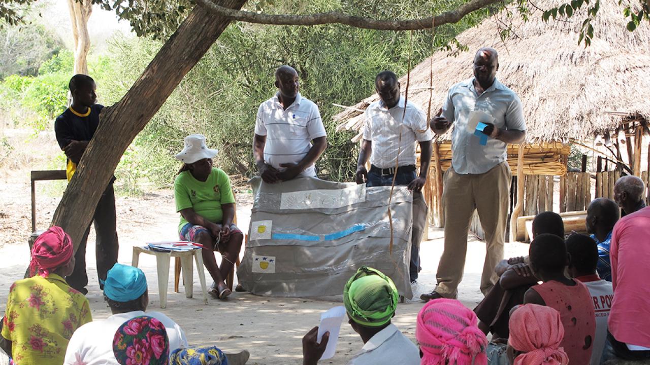 Research team explaining how drought-tolerant maize and index insurance work to a community in rural Mozambique. Photo credit: Jonathan Malacarne / MRR Innovation Lab research in Mozambique
